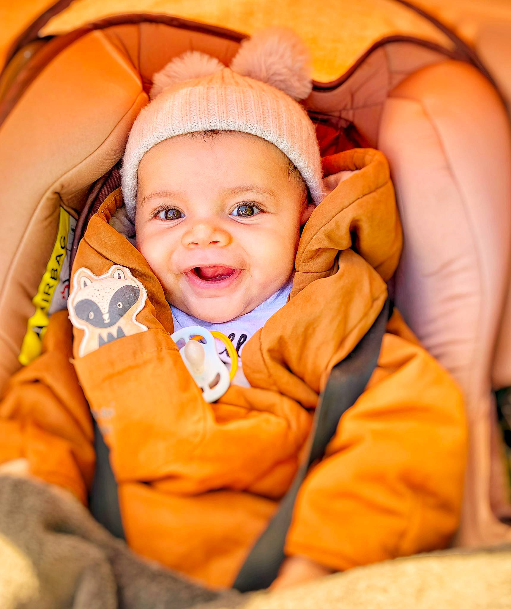 Ay a rejoint le concours — aidez-le/la à gagner de superbes lots ! baby, baby_toddler_clothing, cheek, child, comfort, eye, fashion_accessory, finger, flash_photography, fun, happy, headwear, human_body, iris, orange, outerwear, person, sitting, skin, sleeve