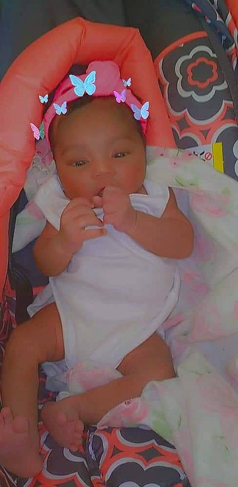 A'Mora is registered to the contest to win money with this photo: baby, baby_toddler_clothing, cheek, child, eye, eyelash, face, head, iris, lip, mouth, nail, pattern, person, petal, pink, skin, textile, thumb, toddler