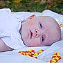 Harper joined the competition — help win amazing prizes! baby, infant, candy_corn, white_blanket, outdoor, grass, face, blue_eyes, lying_down, soft_light, child, cute, young_child, clothing, skin, head, resting, holiday_candy, autumn, calm