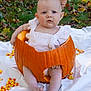 Harper joined the competition — help win amazing prizes! baby, pumpkin, candy_corn, outdoor, grass, hand, white_clothing, fall, autumn, child, cute, sitting, hollow_pumpkin, leaf, nature, seasonal, festive, portrait, person, support