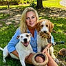 animal, bench, blonde_hair, casual_clothing, dog, dog_toy, friendship, grass, happy, leisure, nature, outdoor, park, pet, playing, relaxation, smiling, sunlight, tree, woman