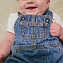 baby, denim_overalls, headband, smile, happy, infant, cute, clothing, child, portrait, skin, hand, face, eyes, cheeks, indoors, fabric, soft, background, lying_down