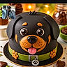 bakery, cake, celebration, chocolate, collar, dessert, dog, dog_cake, fondant, food, green, indoor, orange, paw_print, phone_screenshot, rottweiler, table, tongue, warm_lighting, watermark