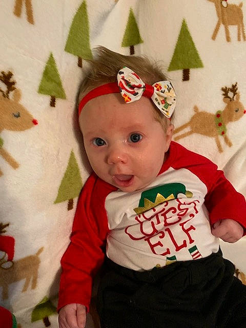 Cheyenne is registered to the contest to win money with this photo: baby, baby_toddler_clothing, cap, child, christmas, christmas_ornament, costume_hat, event, face, happy, head, headgear, headwear, human_body, mammal, party_supply, person, sleeve, surprise, textile