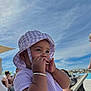 Ophelia joined the competition — help win amazing prizes! toddler, child, hat, purple, sunhat, bracelet, outdoor, poolside, sky, clouds, people, relaxing, summer, sunny, chewing, portrait, candid, vacation, clothing, baby