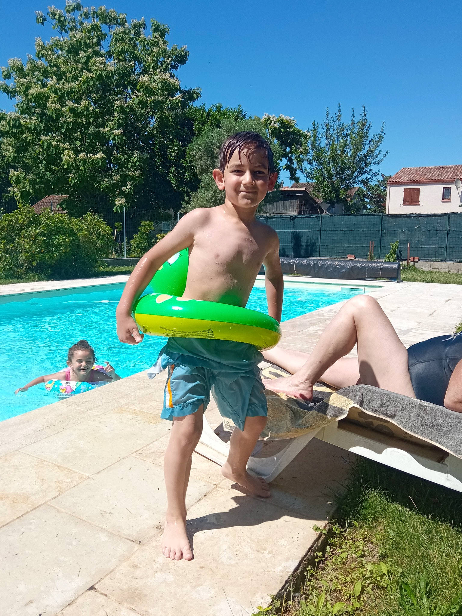 Liam participe au concours pour gagner de l'argent avec cette photo : barechested, barefoot, board_short, boats_and_boating_equipment_and_supplies, foot, fun, happy, joy, leisure, outdoor_furniture, outdoor_recreation, person, plant, recreation, sky, smile, swimming_pool, swimwear, thigh, tree