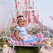Felicity joined the competition — help win amazing prizes! baby, child, dress, headband, carriage, doll, plush_toy, grass_rug, castle_backdrop, butterfly, smiling, sitting, indoor, pink, blue, curly_hair, toy, playful, portrait, happy
