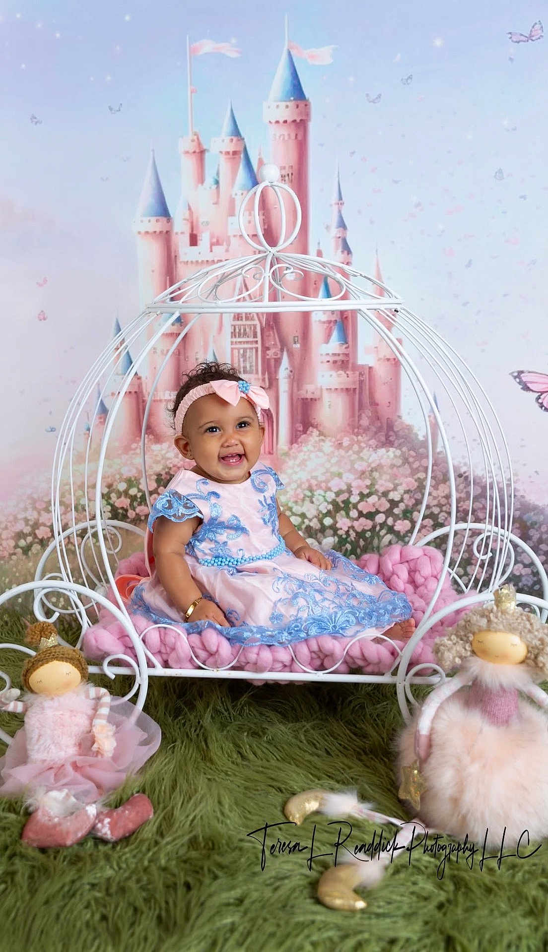 Felicity joined the competition — help win amazing prizes! baby, child, dress, headband, carriage, doll, plush_toy, grass_rug, castle_backdrop, butterfly, smiling, sitting, indoor, pink, blue, curly_hair, toy, playful, portrait, happy