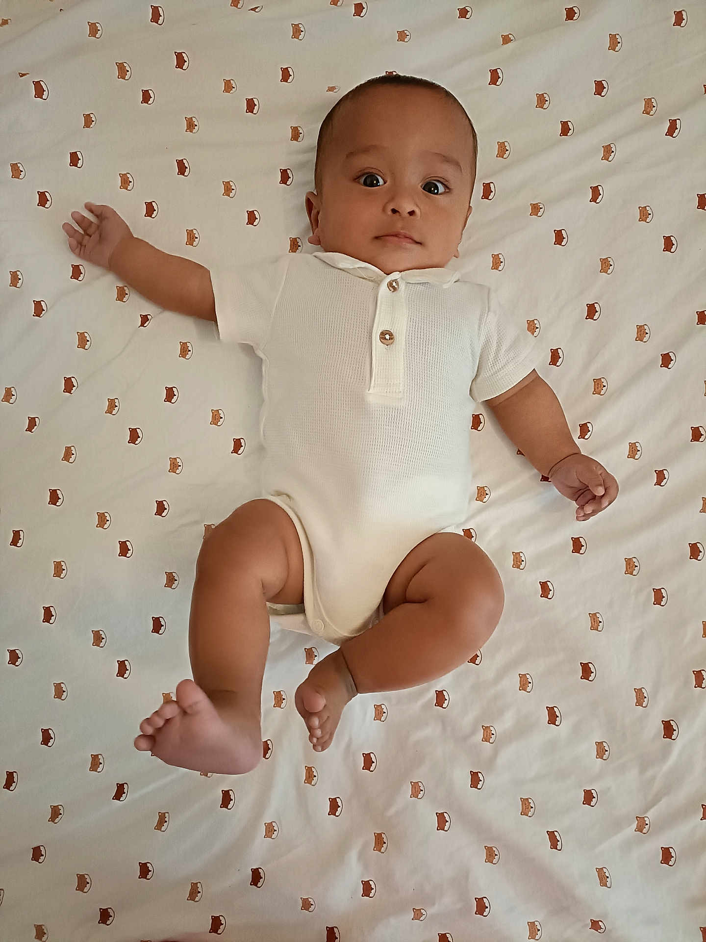 Charles a rejoint le concours — aidez-le/la à gagner de superbes lots ! baby, infant, white_onesie, lying_down, patterned_sheet, fox_pattern, curious_expression, wide_eyes, arm_outstretched, barefoot, indoors, child, cute, young, skin, head, face, legs, hands, person