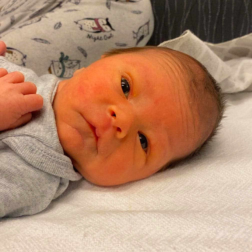 Onyx Beatty joined the competition — help win amazing prizes! baby, blanket, cozy, expression, eyes, face, gray_clothing, head, indoors, infant, lying_down, newborn, pajamas, portrait, resting, skin, small_hands, snowman_print, soft_lighting, young_child