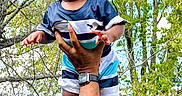 Brexton is registered to the contest to win money with this photo: baby, child, drool, hand, arm, watch, outdoor, trees, greenery, sky, nature, person, clothing, shorts, tshirt, cute, happy, playful, portrait, summer
