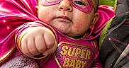 Deliah is registered to the contest to win money with this photo: adorable, baby, blanket, cape, child, closeup, costume, cute, expression, fist, glowing_effects, indoor, mask, pink, portrait, power_pose, superbaby, superhero, vibrant_colors, young_child