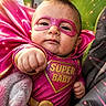 baby, child, superhero, costume, pink, mask, fist, cape, cute, portrait, indoor, blanket, closeup, expression, power_pose, vibrant_colors, glowing_effects, young_child, superbaby, adorable