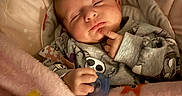 Deliah joined the competition — help win amazing prizes! baby, sleeping, blanket, pacifier, onesie, infant, cozy, cute, child, face, hand, resting, soft, pink, patterned_clothing, indoors, portrait, peaceful, young, head