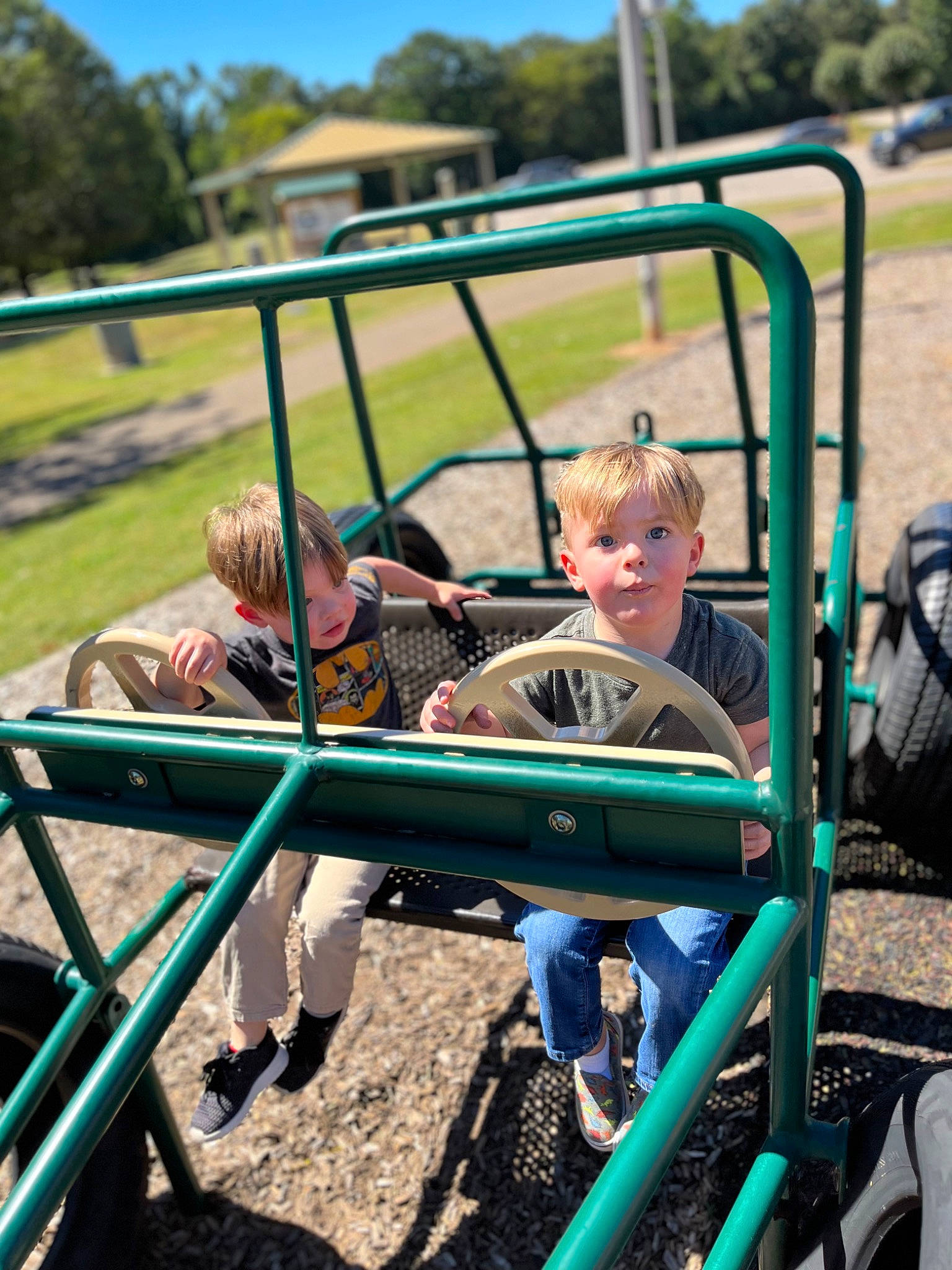 Phoenix is registered to the contest to win money with this photo: automotive_tire, child, city, event, fun, grass, leisure, motor_vehicle, outdoor_play_equipment, outdoor_recreation, person, plant, recreation, shorts, sitting, soil, sunglasses, t_shirt, toddler, tree