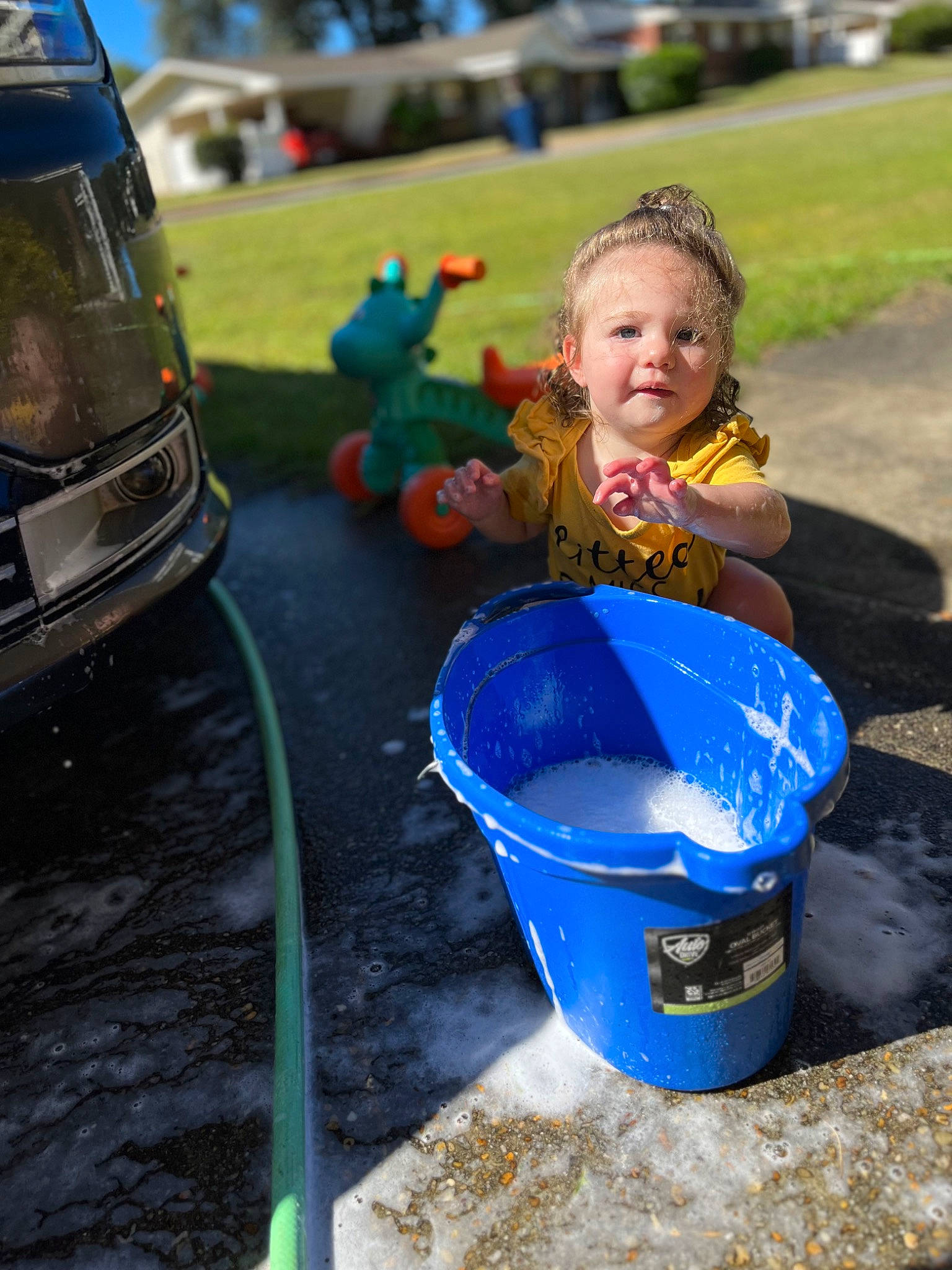 Ophelia is registered to the contest to win money with this photo: baby, car, child, city, electric_blue, fun, grass, leisure, outdoor_play_equipment, person, plastic, play, playground, public_space, recreation, riding_toy, soil, toddler, toy, toy_vehicle