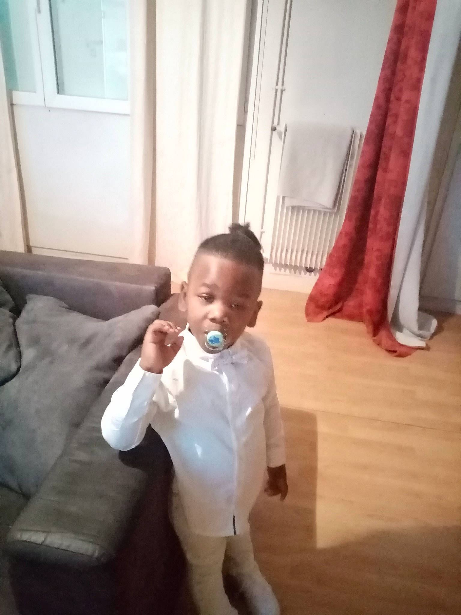 Leandro participe au concours pour gagner de l'argent avec cette photo : baby, baby_toddler_clothing, comfort, couch, curtain, event, floor, flooring, foot, formal_wear, gesture, happy, hardwood, human_leg, laminate_flooring, person, sleeve, toddler, trunk, window