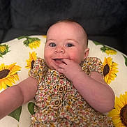 Bryxlee joined the competition — help win amazing prizes! baby, child, smiling, floral_dress, sunflower, cushion, indoor, portrait, happy, cute, infant, hand, face, person, skin, eyes, head, colorful, comfort, fabric
