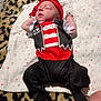Halton is registered to the contest to win money with this photo: baby, infant, sleeping, pirate_costume, red_bandana, striped_clothing, blanket, star_pattern, leopard_print, soft_fabric, footed_pants, cute, costume, indoors, resting, child, person, sleep, infant_clothing, legs