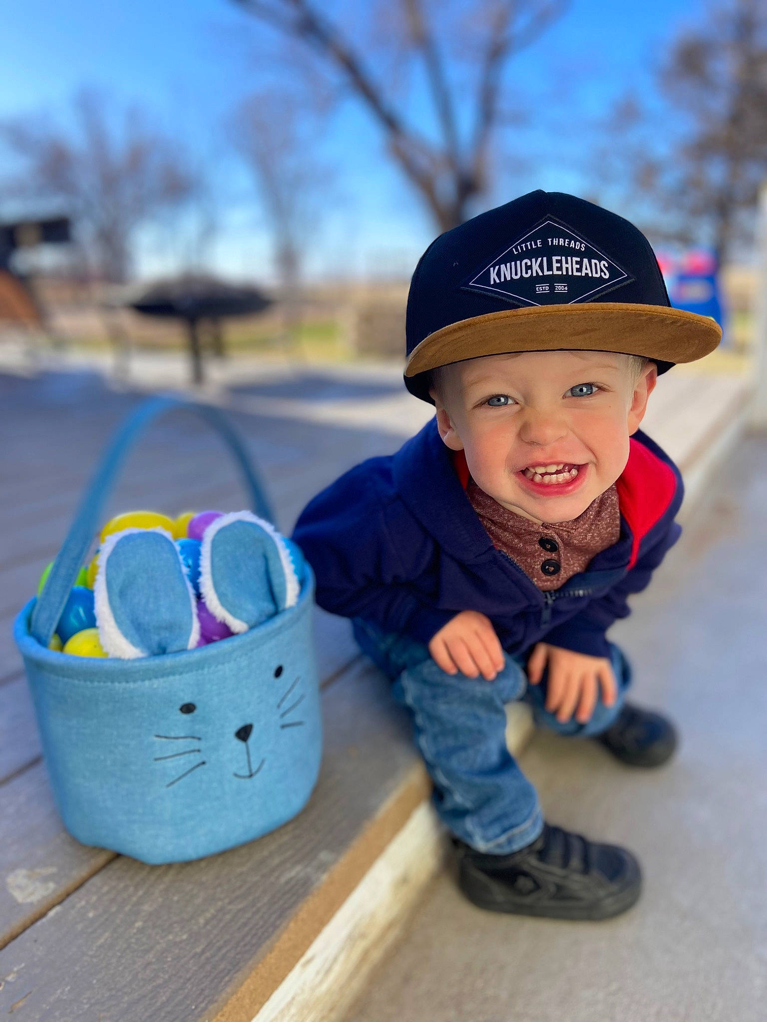 Luke is registered to the contest to win money with this photo: baby, baby_toddler_clothing, basket, cap, child, electric_blue, fun, grass, happy, hat, headwear, jacket, joy, leisure, pattern, people_in_nature, person, plant, recreation, sky