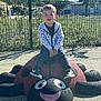 Arthur participe au concours pour gagner de l'argent avec cette photo : boy, casual_clothing, child, daytime, fence, grass, happy, ladybug, nature, outdoor, park, play, playground, recreation, sculpture, smiling, sneakers, sunny, trees, young