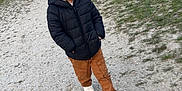 Arthur a rejoint le concours — aidez-le/la à gagner de superbes lots ! autumn, backpack, boy, brick_wall, brown_pants, casual_clothing, child, daylight, grass, gravel_path, nature, outdoor, park, people, puffer_jacket, serious_expression, social_group, trees, walking, white_shoes