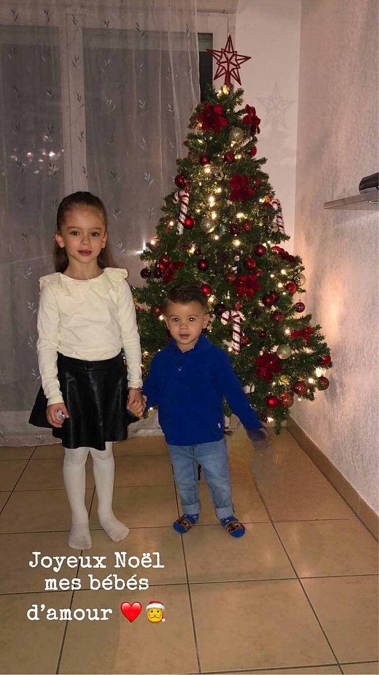 Kaïs a rejoint le concours — aidez-le/la à gagner de superbes lots ! christmas, christmas_decoration, christmas_ornament, christmas_tree, conifer, event, evergreen, facial_expression, fun, happy, holiday, holiday_ornament, human_body, joy, ornament, person, plant, smile, standing, toddler