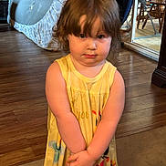 Arianna joined the competition — help win amazing prizes! carpet, casual_clothing, child, curtains, cute, expression, flooring, furniture, hands_clasped, home, indoor, person, portrait, room, short_hair, standing, toddler, wooden_floor, yellow_dress, young_child