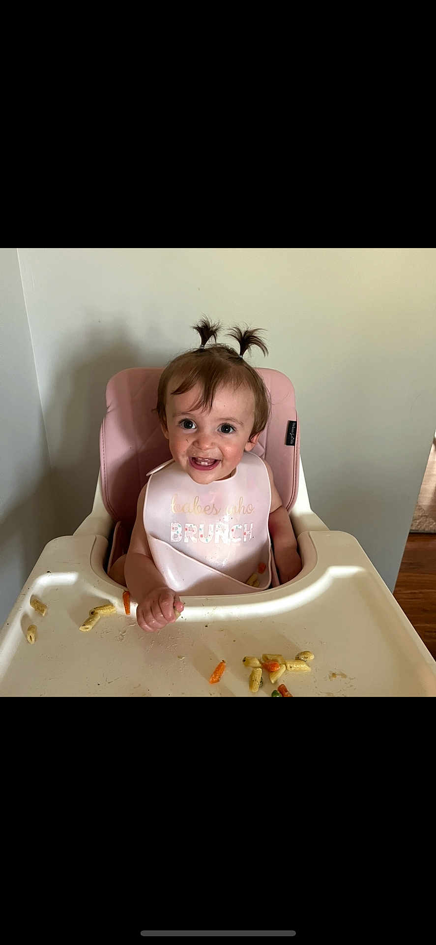Bonnie is registered to the contest to win money with this photo: toddler, child, high_chair, bib, food, snack, smile, happy, indoor, pigtails, hair, face, person, baby_food, plastic, tray, feeding, cute, messy, eating