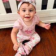 Solena joined the competition — help win amazing prizes! baby, bunny_ears, child, crib, cute, floral_pants, girl, happy, headband, headwear, indoors, person, pink_clothing, portrait, sitting, slippers, smiling, white_furniture, wooden_floor, young_child