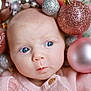 baby, blue_eyes, pink_sweater, christmas_ornaments, glitter, holiday, cute, infant, face, portrait, soft_lighting, close_up, decorations, newborn, skin, child, expression, festive, pink, silver