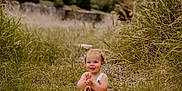 Kylo is registered to the contest to win money with this photo: baby, child, grass, outdoor, blanket, nature, happy, smiling, clapping, infant, grassland, field, sunlight, portrait, young_child, one_year_old, cute, sitting, casual_clothing, daytime