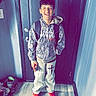 teenager, child, smiling, portrait, standing, doorway, indoors, entryway, jacket, hoodie, backpack, pants, red_shoes, fashion, casual_clothing, wooden_floor, door, shoes, happy, full_body