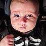 Nélya participe au concours pour gagner de l'argent avec cette photo : baby, infant, face, eyes, expression, hand, fist, clothing, skeleton_print, car_seat, seatbelt, black_clothing, closeup, portrait, child, cute, indoors, person, young, skin