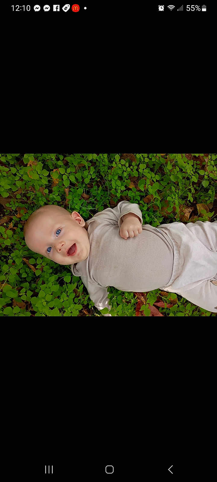 Vincent is registered to the contest to win money with this photo: baby, infant, smiling, happy, blue_eyes, lying_down, greenery, leaves, nature, outdoor, clothing, beige_outfit, cute, child, person, skin, head, hand, baby_girl, baby_boy
