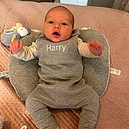 Harry joined the competition — help win amazing prizes! baby, infant, grey_outfit, pacifier, plush_toy, blanket, cushion, lying_down, cute, soft_texture, indoors, child, newborn, sock, expression, face, person, comfort, cozy, home