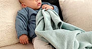 Elhan a rejoint le concours — aidez-le/la à gagner de superbes lots ! baby, blanket, blue_blanket, blue_clothes, child, couch, cozy, household, indoor, infant, living_room, looking_away, pillow, plush, portrait, relaxed, sitting, socks, sofa, soft_texture