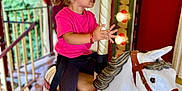 Manelle a rejoint le concours — aidez-le/la à gagner de superbes lots ! toddler, child, carousel, horse, ride, amusement_park, pink_shirt, white_horse, smiling, fun, playful, outdoor, wooden_floor, lights, decorative, hair_tied, sneakers, seatbelt, holding_pole, portrait