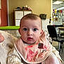 Zely a rejoint le concours — aidez-le/la à gagner de superbes lots ! baby, infant, bib, big_eyes, portrait, indoor, person, sitting, blanket, sweater, feeding_bib, pink, chair, caregiver, nursery, expression_surprised, closeup, face, mouth_open, gaze_camera