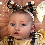 Zely a rejoint le concours — aidez-le/la à gagner de superbes lots ! baby, infant, child, headband, bow, plaid, blanket, portrait, closeup, big_eyes, romper, straps, cute, pink_background, soft_texture, face, skin, ears, gaze, nursery