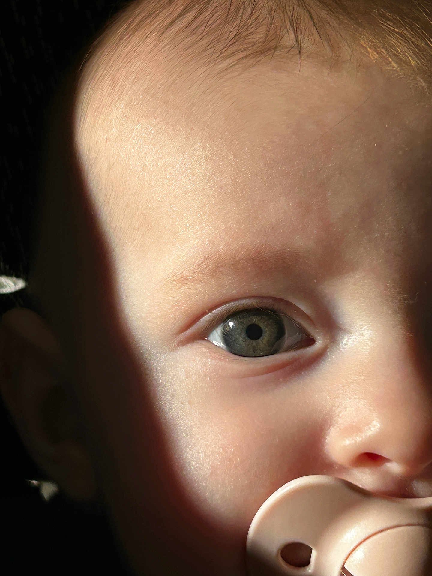 Zely participe au concours pour gagner de l'argent avec cette photo : baby, infant, child, close_up, eye, iris, pupil, pacifier, mouth, cheek, forehead, skin, eyelashes, nostril, lighting, shadow, face, portrait, curious, soft_texture