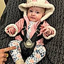 baby, infant, child, car_seat, safety_harness, hood, fur_trim, pink_jacket, floral_print, socks, hand, adult_hand, finger_pointing, buckle, closeup, portrait, eyes, gaze, cozy, patterned_fabric