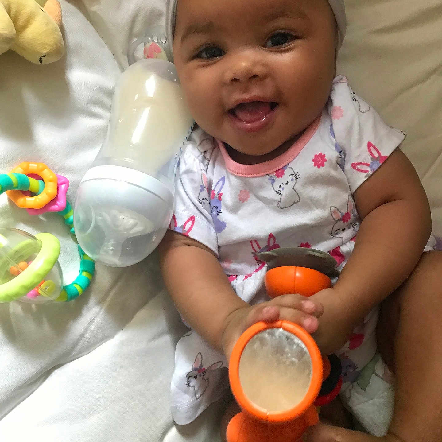 Aavia joined the competition — help win amazing prizes! baby, bottle, child, clothing, colorful, cute, expression, foot, hand, happy, headband, indoors, infant, lying_down, mirror, play, skin, smiling, soft_surface, toy