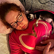 Bella participe au concours pour gagner de l'argent avec cette photo : woman, dog, small_dog, black_and_white, sleeping, glasses, bed, pillow, shirt, pink, indoors, portrait, pet, resting, lying_down, couch, blanket, human_face, companion, cozy