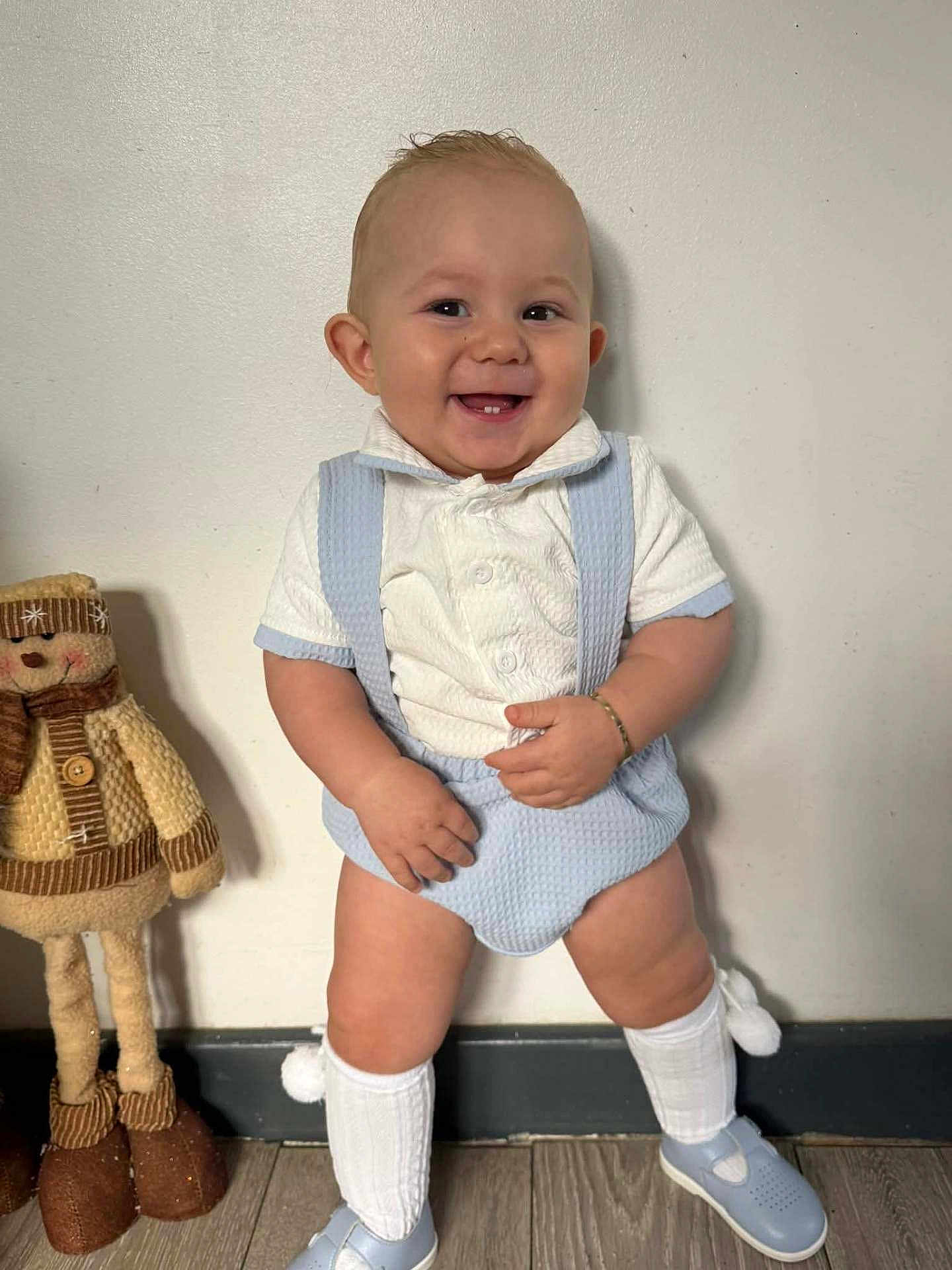 Dalton joined the competition — help win amazing prizes! baby, child, smile, standing, blue_outfit, white_shirt, knee_socks, shoes, stuffed_toy, doll, wooden_floor, wall, bracelet, happy, indoors, cute, playful, person, portrait, fashion