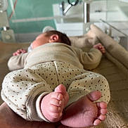 Marceau participe au concours pour gagner de l'argent avec cette photo : baby, infant, feet, hand, knitted_blanket, clothing, sleeping, blurred_background, indoor, soft_light, skin, newborn, cute, tiny, peaceful, resting, warm, comfort, parent, care