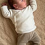 baby, infant, blanket, knitwear, socks, side_profile, face, person, sleepwear, soft_texture, lying_down, young_child, cozy, neutral_colors, portrait, cute, child, small_hands, small_feet, peaceful