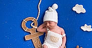 Dominic is registered to the contest to win money with this photo: anchor, baby, blue_background, creative, cute, decorative, felt_clouds, infant, knit_hat, knit_overalls, laying_down, nautical, newborn, peaceful, portrait, props, rope, sleeping, soft_toys, studio_photo