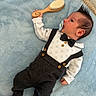 baby, blue_blanket, bow_tie, button, child, clothing, cute, face, hairstyle, hand, indoors, infant, lying_down, pacifier, portrait, red_socks, smiley_face, soft_texture, suspenders, wooden_brush