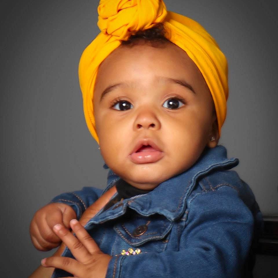 Tahiry is registered to the contest to win money with this photo: baby, cheek, child, child_model, clothing, ear, eye, face, hair_accessory, head, headband, headgear, iris, lip, mouth, organ, person, photography, toddler, turban